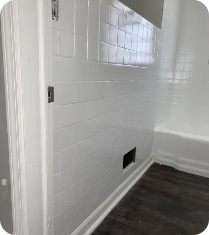 a white tile wall with a hole in the wall