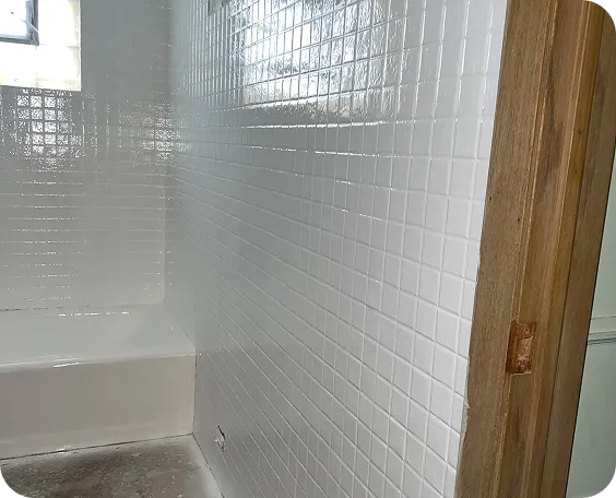 a white tile wall in a bathroom
